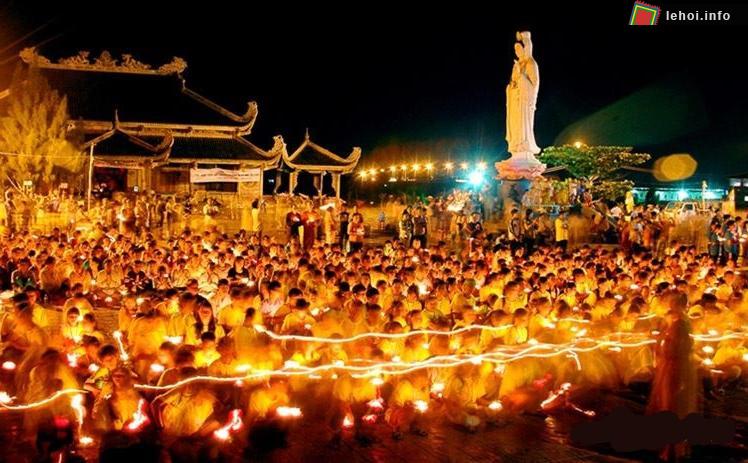 Phật tử và khách hàng hương cùng thắp nến hoa sen dưới chân tượng Bồ Tát Quan Thế Âm
