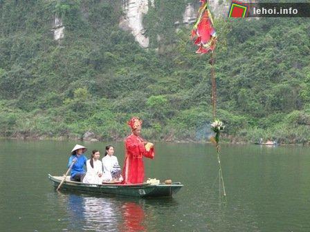Chiếc thuyền chở ông chủ tế và 2 trinh nữ đang làm nghi thức bên cạnh cây tre trồng trên mặt sông