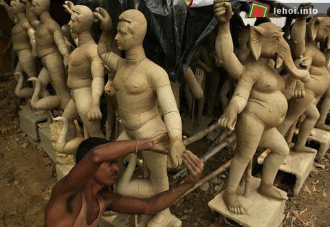 Một nghệ sĩ đang chỉnh lại những tượng thần Hindu trước khi festival Durga Puja diễn ra ở tại Allahabad , Ấn Độ.   