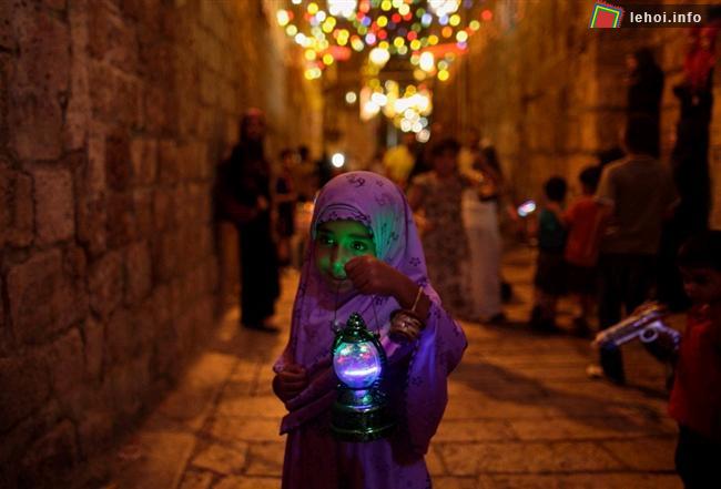 Một cô bé người Palestin đang đi trên đường phố của Jerusalem  và cầm trên tay chiếc lồng đèn truyền thống của lễ Ramadan. 
