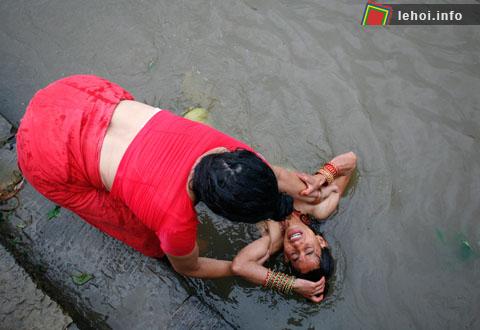 Một tín đồ Hindu đang trầm mình xuống nước sông Ganges tại Allahabad , Ấn Độ trong một lễ nghi Pind Daan.   