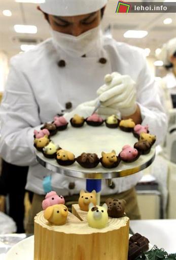 Một người thợ làm bánh trang trí cho các viên chocolate ngộ nghĩnh tại một cửa hàng nhân sự kiện 