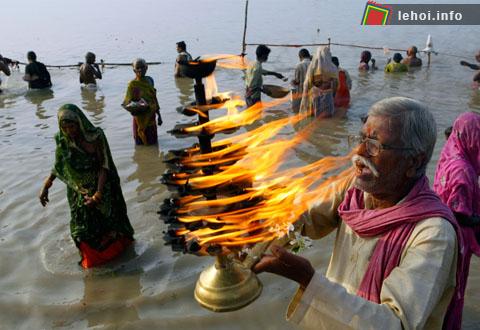 Một tín đồ Hindu đang cầu nguyện trên sông Ganges với cây đèn truyền thống tại Allahabad , Ấn Độ.   
